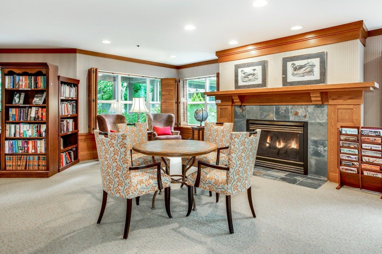 Library hearth room with fireplace and reading table at Silver Glen